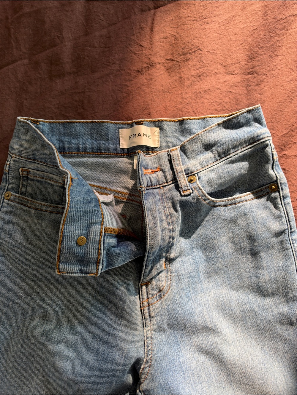 FRAME high-rise wide-leg jeans in a light/medium blue wash.